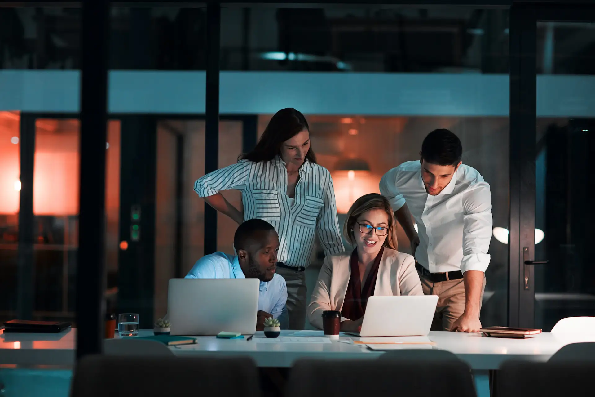 A professional working late at a desk with multiple screens
