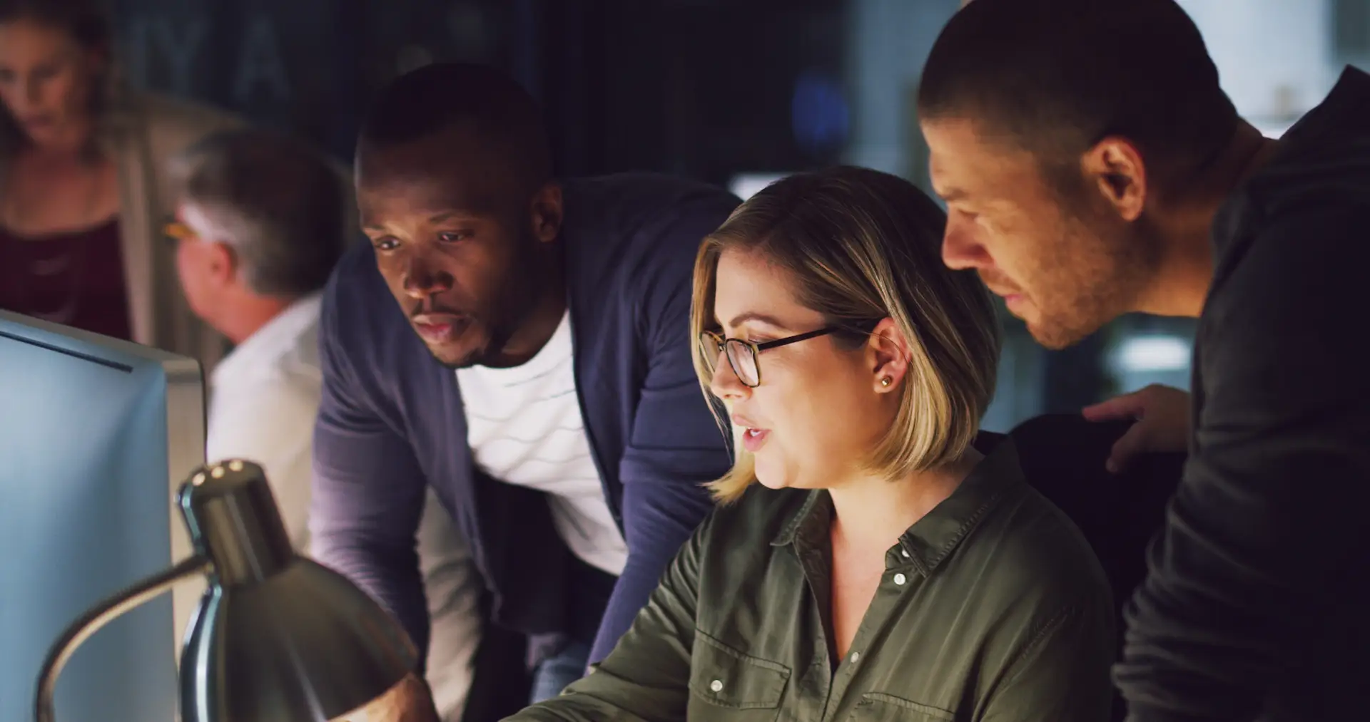 A digital team collaborating around a computer